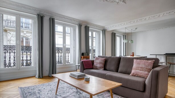 Una sala de estar moderna con un sofá, una mesa de centro y vistas a un balcón.