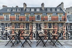 A terrace with outdoor seating and a wrought iron railing. - Blueground | La Muette, near restaurants & shops (Paris)
