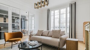 Ein modernes Wohnzimmer mit einer Couch, einem Glastisch und einem Holznachttisch.