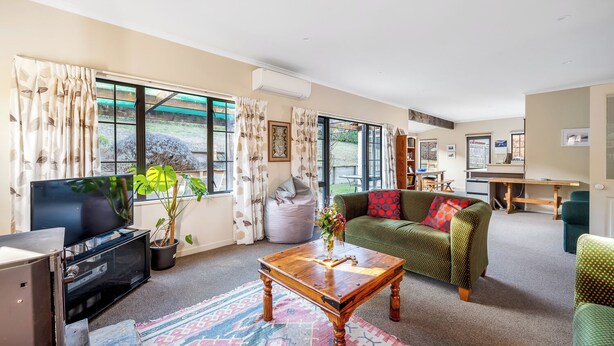 A living room with a TV, sofa, coffee table, and large windows. - Criffel Peak Cottage, quiet location, only 10 min walk into Wanaka town centre (Wānaka)