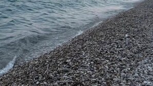 A pebbled beach with calm water and distant mountains. - Nissaki Rooftop Oceanview two bedroom apartment with WiFi and air conditioning (Nisaki)