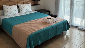 A neatly arranged bedroom with a bed, a bedside table, and a window with curtains. - Nissaki Rooftop Oceanview two bedroom apartment with WiFi and air conditioning (Nisaki)