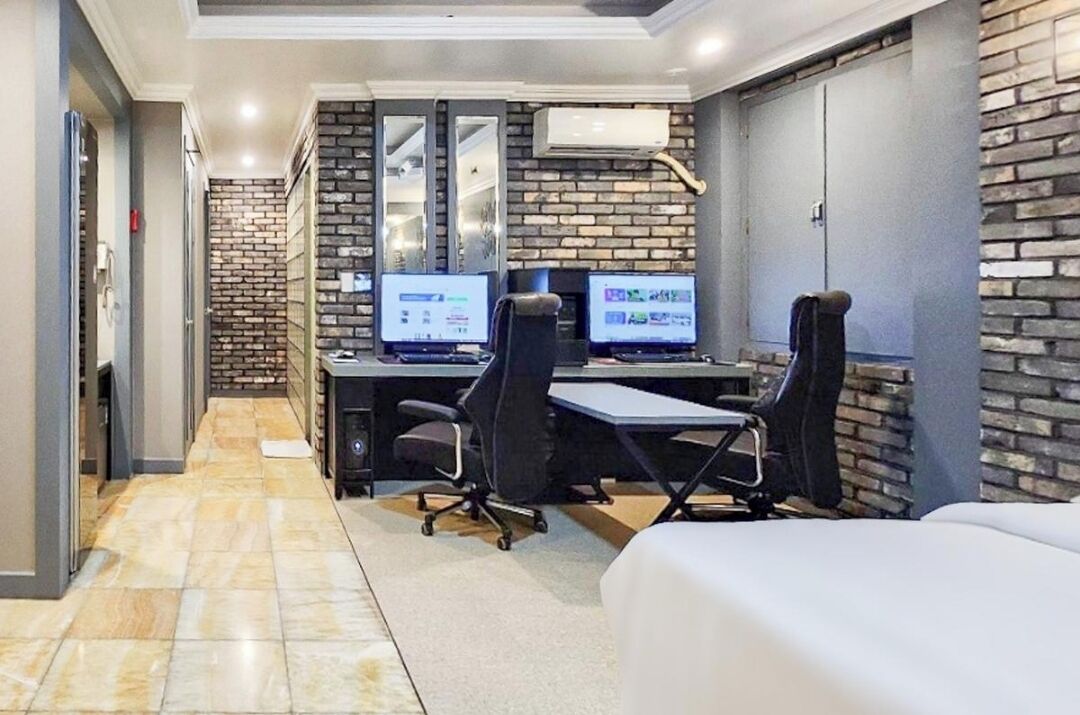 A modern office space with two desks, two chairs, and a large mirror.