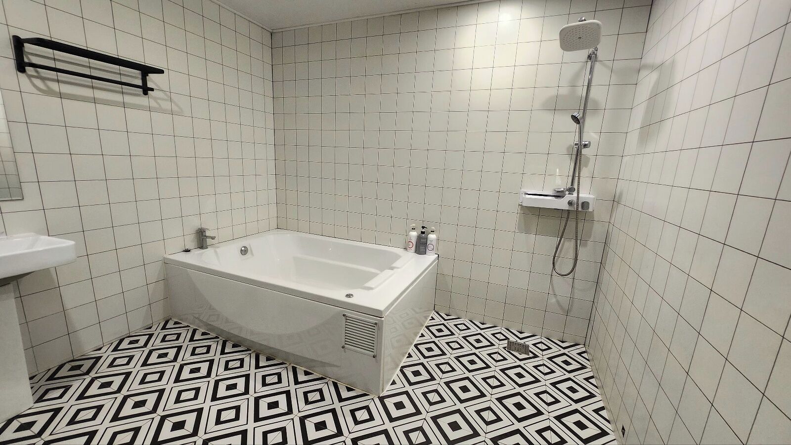 Un baño con bañera, ducha y lavamanos.