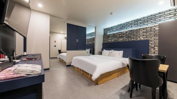 A modern hotel room with a large bed, a desk, and a seating area. - Pyeongtaek Station Gallery Hotel (Pyeongtaek)