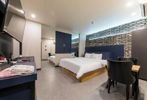 Una habitación de hotel moderna con una cama grande, un escritorio y una zona de estar.