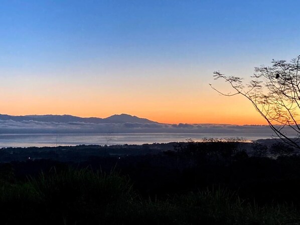 Eine Landschaftsansicht mit einem Berg in der Ferne und wolkenlosem Himmel.