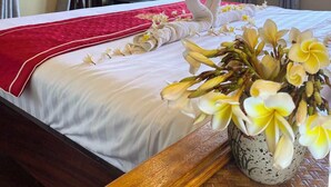 Une chambre d’hôtel avec un lit, une télévision, une fenêtre et un plafond en bois.