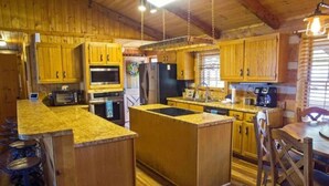 Eine Küche mit Holzschränken, Granit-Arbeitsplatten und einer Kochinsel.