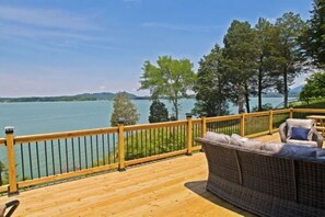 A wooden deck with a railing, overlooking a lake with trees and hills in the distance. - Lake Front, Pet friendly, WiFi (Sevierville)