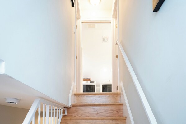 A staircase leading to a laundry room with a door at the top.