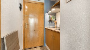 Una cocina con armarios de madera, una encimera y una puerta.