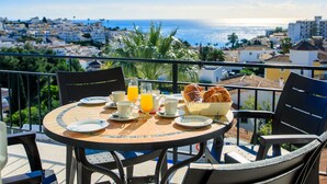 A round table with chairs on a balcony overlooking a coastal cityscape. - Florida by Interhome (Nerja)