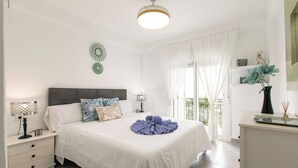 A bedroom with a bed, nightstands, a dresser, a window with curtains, and a ceiling light. - Florida by Interhome (Nerja)