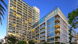 Un hotel de varios pisos con un diseño arquitectónico moderno, con balcones y ventanas amplias.