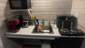 A compact kitchen with a microwave, toaster, and stove. - The Whispering Cedar (Valemount)