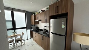 Een moderne keuken met houten kastjes, een roestvrijstalen koelkast en een marmeren vloer.