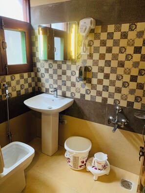 Un baño con lavamanos, inodoro, bidé y espejo.