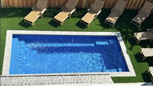 A rectangular swimming pool with a wooden deck surrounding it. - Hotel-Style Suite, 300’ to Beach (Beach Haven)