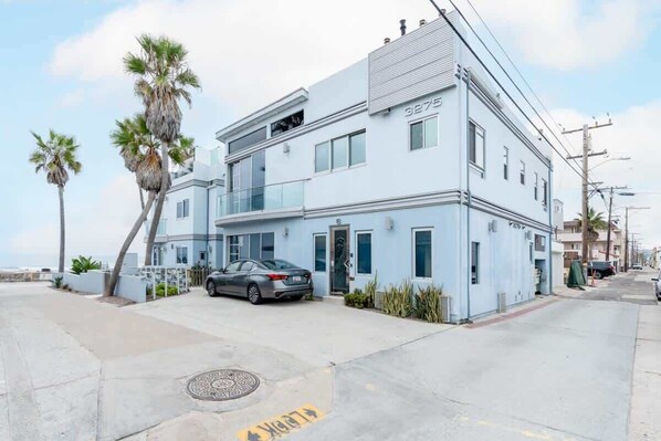A modern two-story building with a car parked in front.