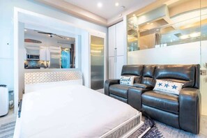 Une chambre d’hôtel moderne équipée d’un lit, d’un canapé et d’une kitchenette.