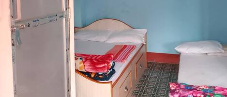 A bedroom with a bed, a wardrobe, and a ceiling fan.