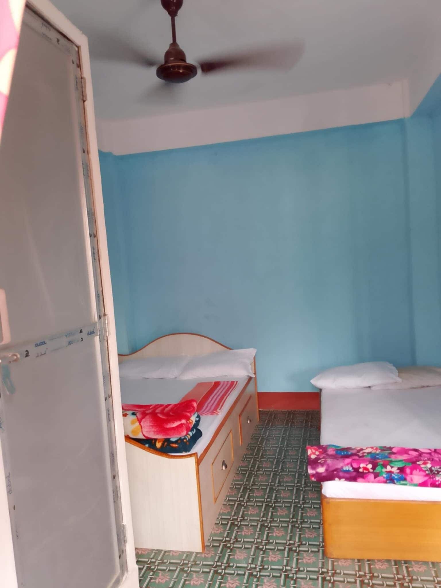 A room with a bed, a wardrobe, and a ceiling fan.