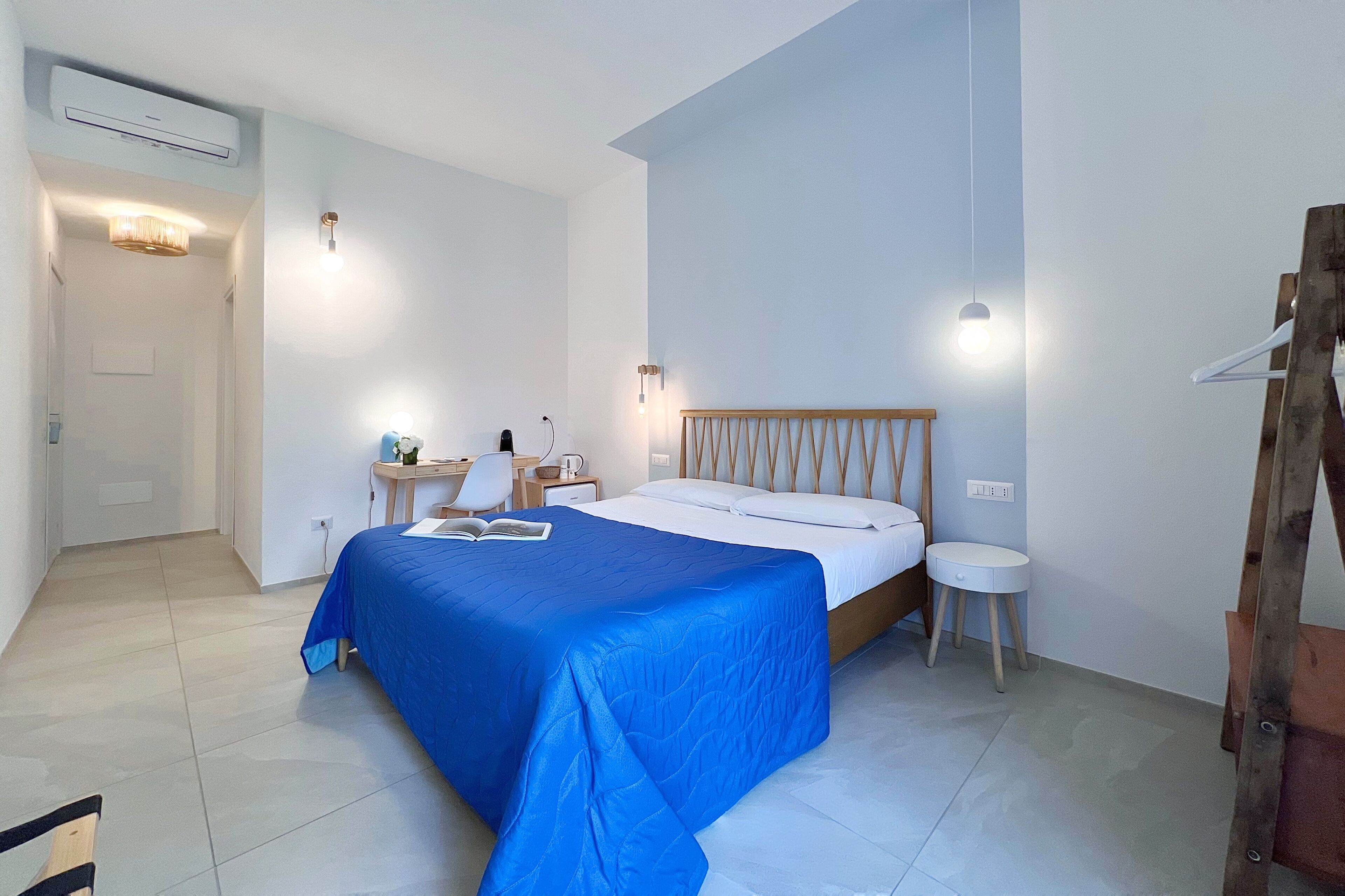 Une chambre à coucher avec un lit, une table de chevet, une lampe et une échelle en bois.