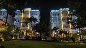 A multi-story hotel with balconies and string lights.