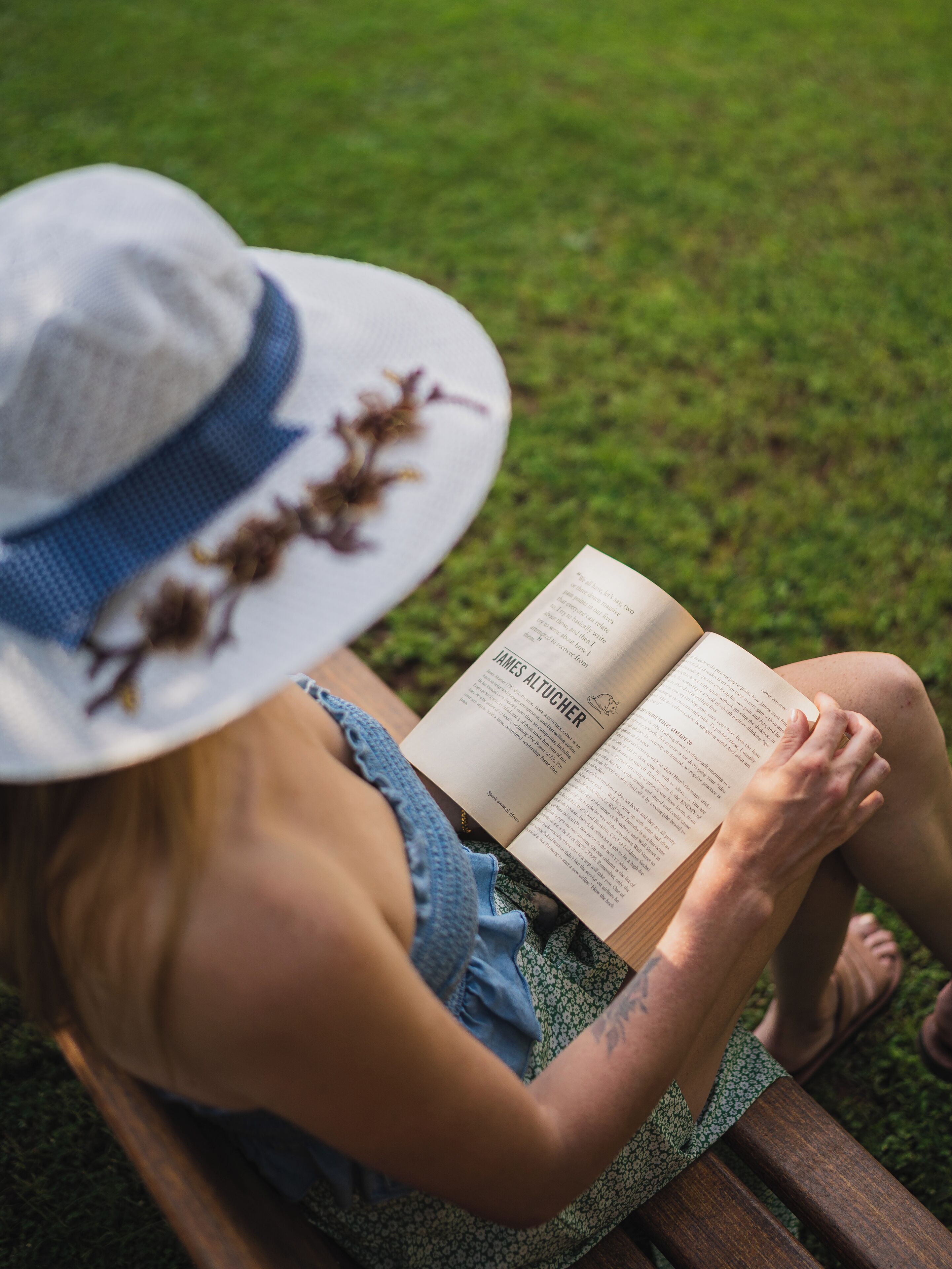 A person reading a book outdoors.