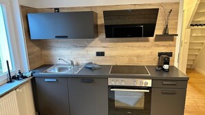 A modern kitchen with a built-in oven, a coffee maker, and a sink. - Tante Hedwig - cozy vacation apartment in Rodalben close to the rock hiking trail (Rodalben)