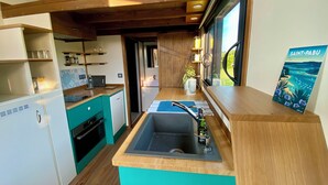 A compact kitchen with a sink, wooden countertop, and a view of Saint-Pabú. - Walk to the beach for ker Ael's Tiny house (Landéda)