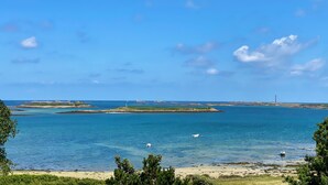 A coastal landscape with clear skies, calm waters, and distant landforms. - Walk to the beach for ker Ael's Tiny house (Landéda)
