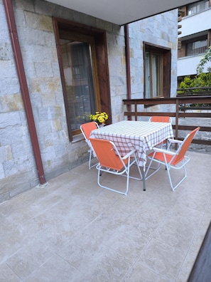 Enjoy a romantic meal for two on this intimate patio, complete with a table, chairs, and a beautiful potted plant.