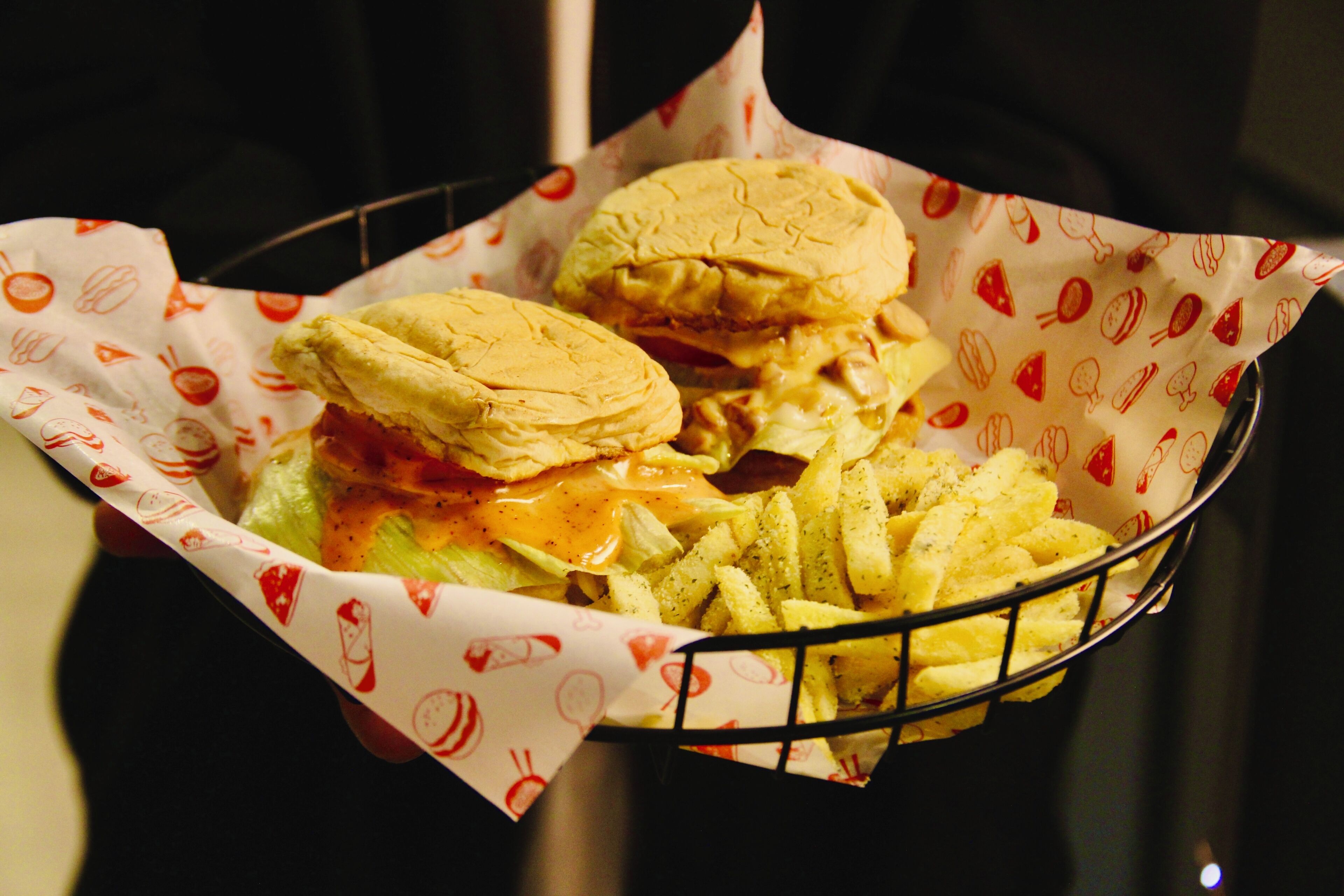 A basket containing two burgers and a side of fries.