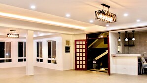 A spacious interior with a staircase, a kitchen area, and multiple windows. - Hidden Oasis Resort (Gingoog)