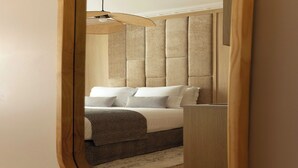 Une chambre à coucher avec un grand lit, une tête de lit, une table de chevet et un luminaire suspendu.