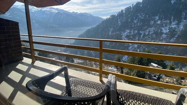 Un balcone con vista su montagne innevate e un lago.