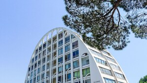 Ein mehrstöckiges Gebäude mit einer geschwungenen Fassade, großen Fenstern und Balkonen.