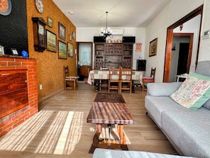 Una sala de estar con chimenea, una mesa de comedor y un sofá.