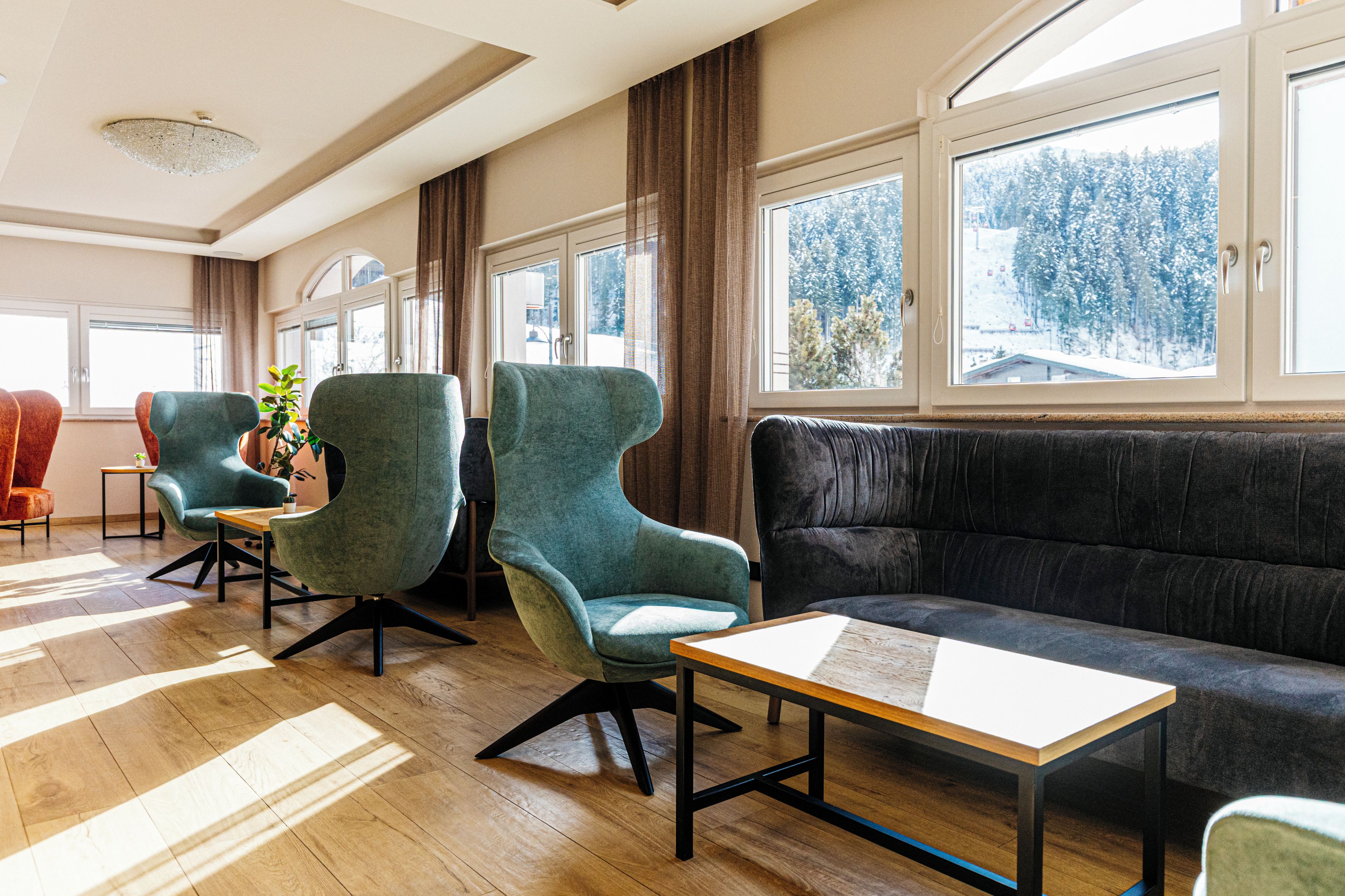 A modern interior with a sofa, two armchairs, and a small table.