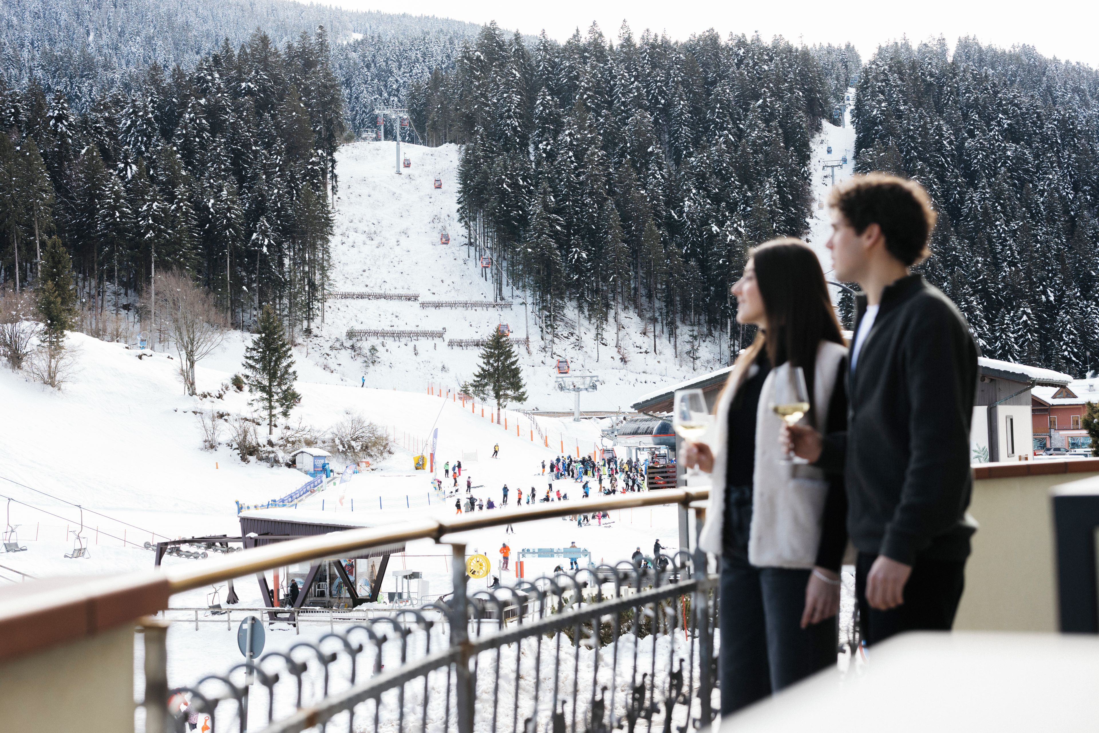 Una pista da sci innevata con una seggiovia e un gruppo di persone.
