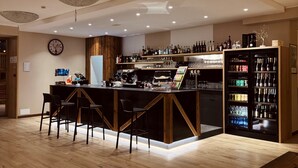 Uma área de bar moderna com piso de madeira, balcão e adega.