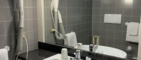 A bathroom with a white sink, a hairdryer, and a mirror.
