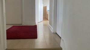 Un escalier menant à une chambre à coucher, avec un tapis rouge au pied de l’escalier.
