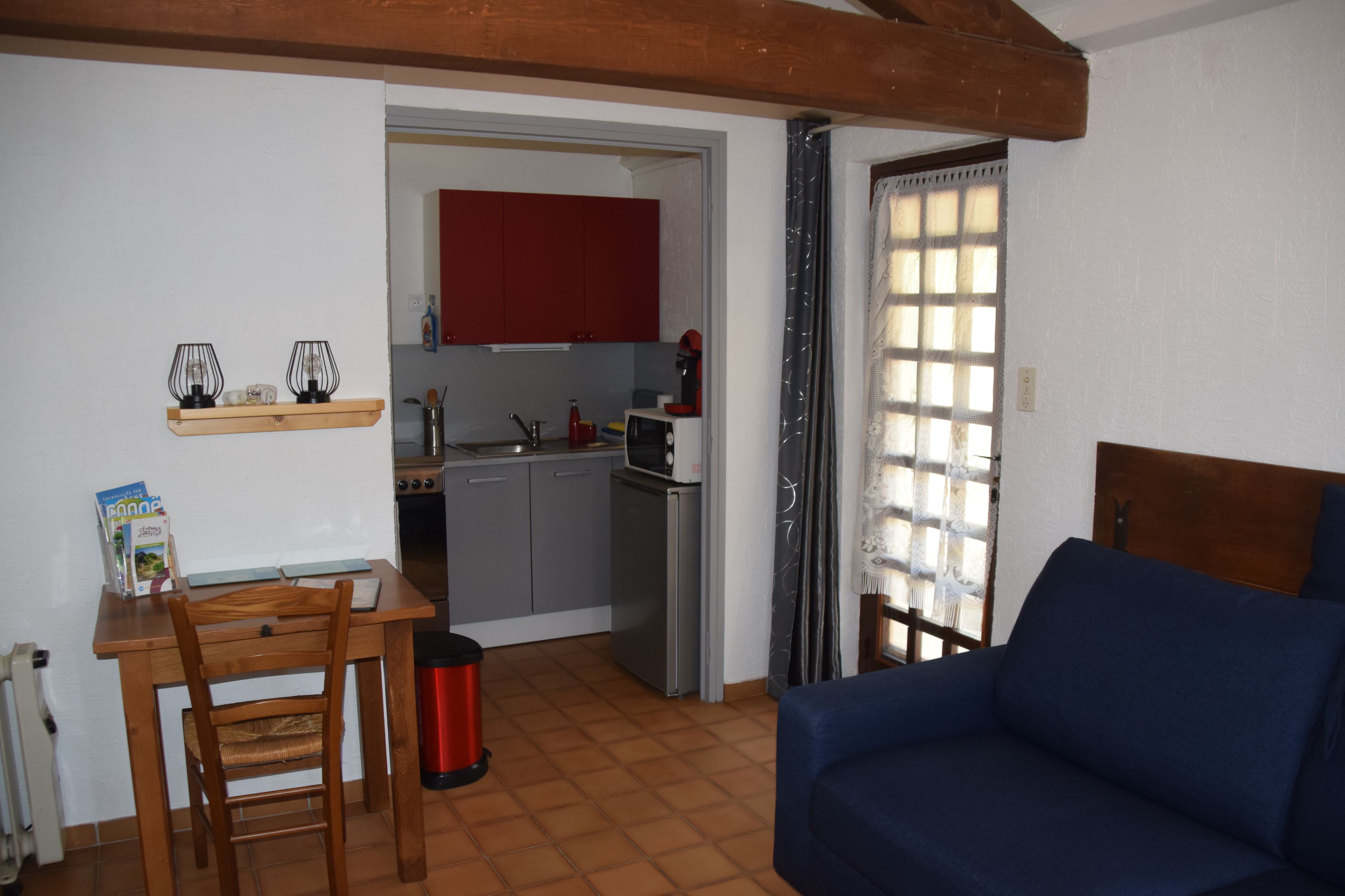Un espace de vie compact comprenant un coin cuisine, un coin repas avec une table et des chaises, et un canapé.