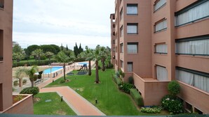 A multi-story building with a pool area, green lawns, and a clear sky. - PLAYA VERDE 37 - Two Bedroom Apartment, Sleeps 5 (Punta del moral)
