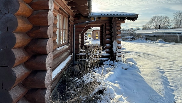 A log cabin with a snow-covered exterior and a visible window. - Fjordhygge (Jægerspris)