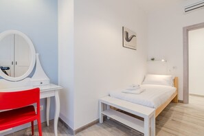 A bedroom with a bed, a bedside table, a desk with a chair, a mirror, and a wall-mounted picture. - Maria Magdalena Apartment Saint Peter's (Roma)
