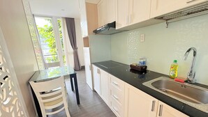 Een moderne keuken met witte kastjes, een zwart aanrecht en een roestvrijstalen spoelbak.